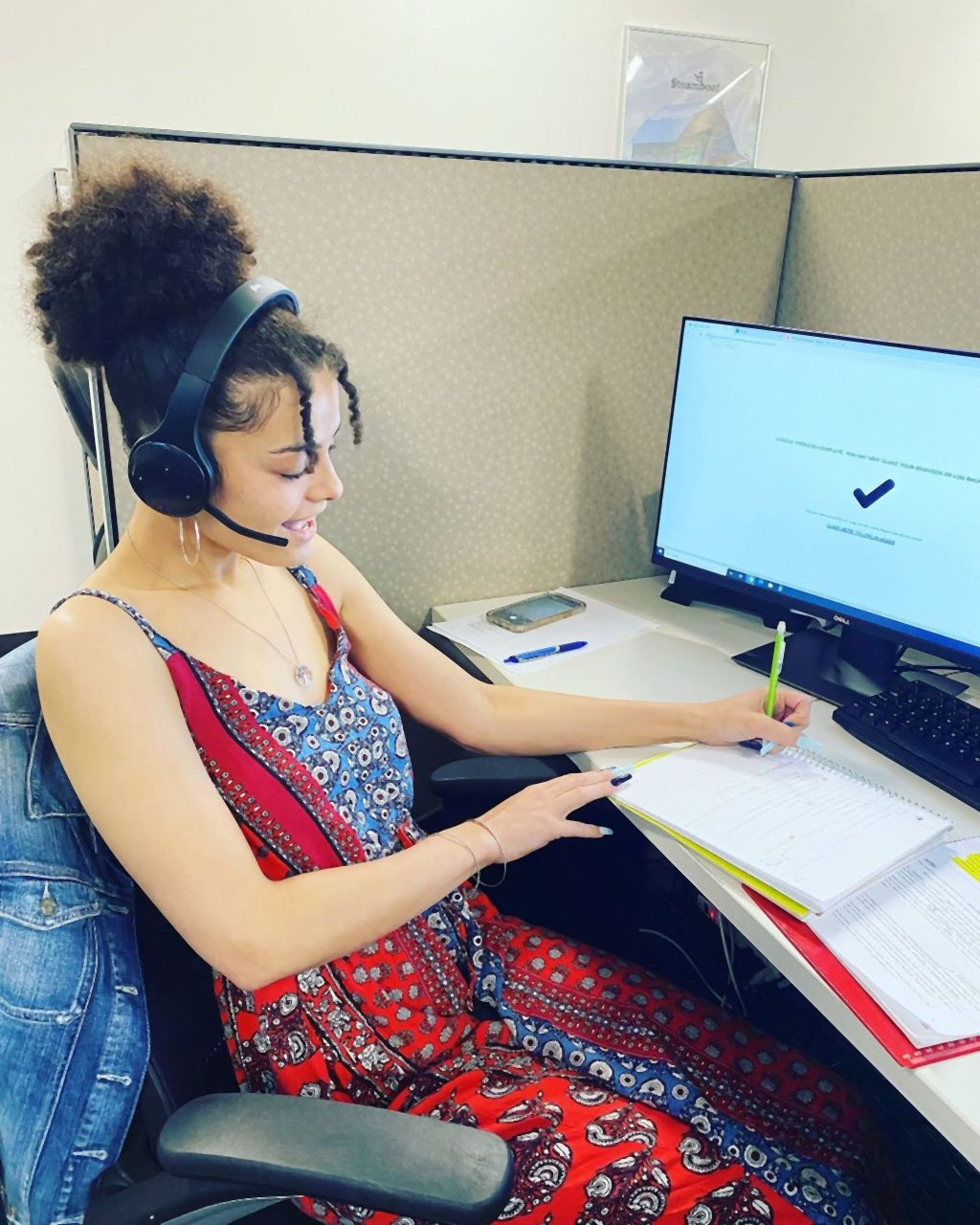 A Senior Solutions agent on a headset taking notes for a client
