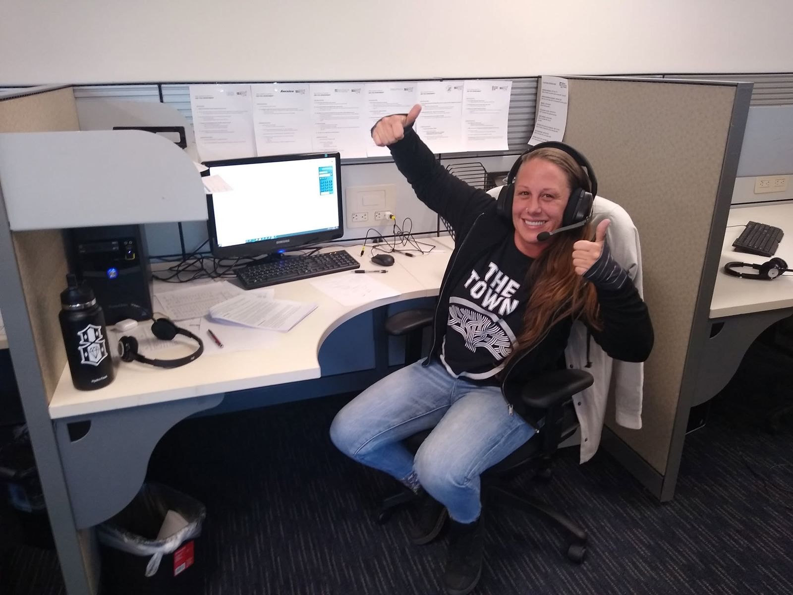 An agent gives a thumbs up from her desk